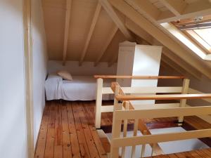 Kleines Dachzimmer mit einem Bett und einem Fenster in der Unterkunft Apartamentos Hacienda de Arna in Somo