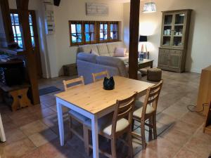 ein Wohnzimmer mit einem Tisch, Stühlen und einem Sofa in der Unterkunft Les Mésanges in Lamotte-Beuvron