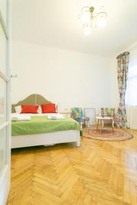 1 dormitorio con 1 cama y suelo de madera en Bright Studio in the Heart of the City with Netflix en Bucarest