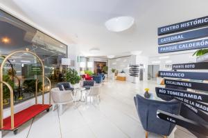 a lobby with chairs and tables in a building at TRYP by Wyndham Cuenca Zahir in Cuenca