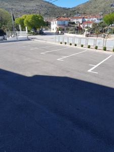 um parque de estacionamento com uma grande sombra no chão em Apartmani MARELLA em Trogir