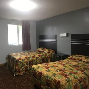 Postel nebo postele na pokoji v ubytování Guest Inn