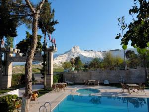 a swimming pool with a mountain in the background at Hotel HAL-TUR in Pamukkale