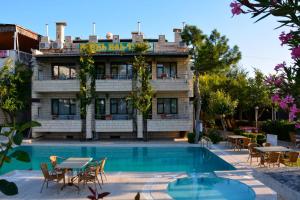 a hotel with a pool and tables and chairs at Hotel HAL-TUR in Pamukkale