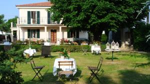 una mesa y sillas frente a una casa en VILLA LE ROSE, en Cavour