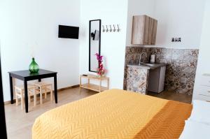 una camera da letto con un letto, un tavolo e una cucina di La Foresteria a Grottaglie