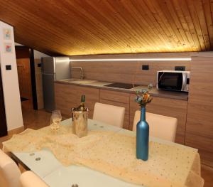 a table with a bottle of wine and a vase on it at Apartment Leona in Pula