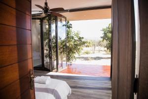 a room with a bed and a door with a view at Kuwisa Lodge in Warmbaths