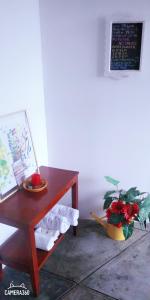 einem Holztisch mit einer Pflanze neben einem Tisch mit einem Regal in der Unterkunft La Casa del Che Fernando in Lima