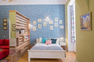 um quarto com uma cama e uma parede azul em City Light Apartment em Timişoara