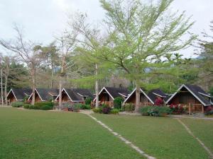 a row of cottages in a park with a lawn at Atunas Holiday Country in Dapu +17 photos