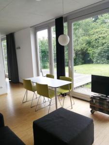 een woonkamer met een tafel en stoelen en een groot raam bij Hotel Sonderborg in Schrobenhausen