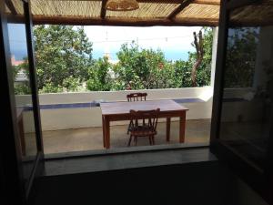 a table and two chairs sitting on a balcony at Angel home in Malfa