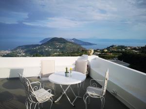 un tavolo bianco e sedie su un balcone con vista di Villa Paradiso a Piano Conte