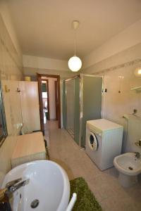 ein Badezimmer mit einem Waschbecken und einer Waschmaschine in der Unterkunft AGAVE in Marina di Campo