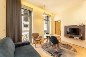 ポルトにあるFeel Porto Codeçal Apartmentsのリビングルーム(ソファ、テーブル、椅子付)