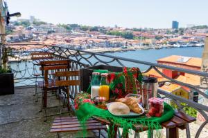 ein Tisch mit einem Teller Essen auf einem Balkon in der Unterkunft Feel Porto Codeçal Apartments in Porto