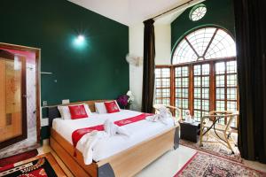 a bedroom with a large bed with a green wall at LikeMyHome Homestay Mysore in Mysore