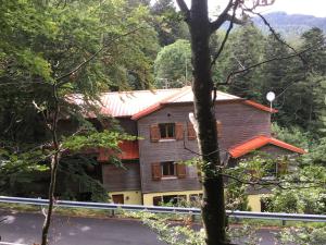 une maison en bois au milieu d'une forêt dans l'établissement HÔTEL RESTAURANT LA FOURMI, à Bourbach-le-Haut