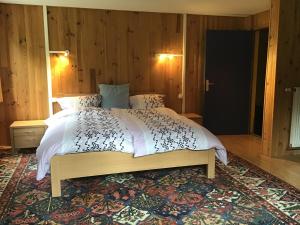 a bedroom with a large bed with white sheets and a rug at HÔTEL RESTAURANT LA FOURMI in Bourbach-le-Haut