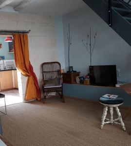 ein Wohnzimmer mit einem Stuhl und einem TV in der Unterkunft La cordonnerie in Loches