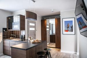 a kitchen with a counter and stools in it at Apartamenty Pocztowa in Bydgoszcz