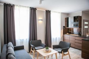 a living room with a couch and two chairs and a table at Apartamenty Pocztowa in Bydgoszcz