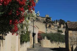 eine Straße in einem Dorf mit einem Schloss im Hintergrund in der Unterkunft Les lavandes de Sèverine in Boulbon