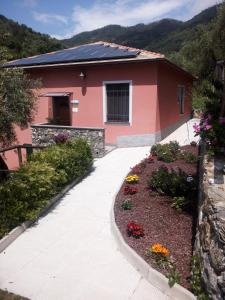 una casa con una pasarela frente a un jardín de flores en Agriturismo A' Taversa, en Levanto