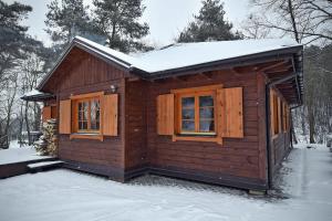 a small wooden cabin with snow on the roof at Domek na Stoku in Kazimierz Dolny