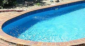 a large blue swimming pool with a brick border at Stannum Lodge Motor Inn in Stanthorpe