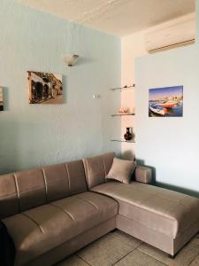 un soggiorno con divano marrone in una camera di Sea View 2 Bedroom Vacation Apartment a Giardini Naxos