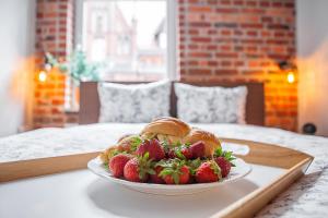 a plate of strawberries and croissants on a table at Apartamenty Pocztowa in Bydgoszcz