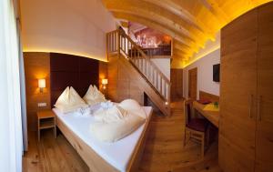 a room with a bed with a staircase in it at Hotel Schiederhof in Grossarl