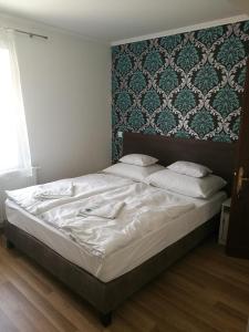 A bed or beds in a room at Halász Vendégház