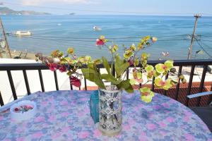 a vase with flowers on a table with a view of the ocean at Anna Koralli Studios in Laganas