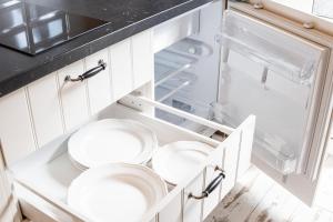 a kitchen with two white plates in an open refrigerator at Apartamenty Pocztowa in Bydgoszcz