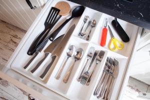 a white drawer filled with utensils on a counter at Apartamenty Pocztowa in Bydgoszcz