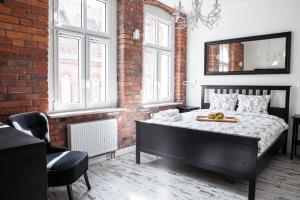 a bedroom with a bed in a brick wall at Apartamenty Pocztowa in Bydgoszcz