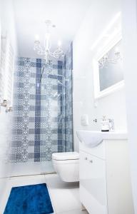a bathroom with a toilet and a sink and a shower at Apartamenty Pocztowa in Bydgoszcz