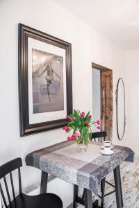 a dining room table with a vase of flowers on it at Apartamenty Pocztowa in Bydgoszcz