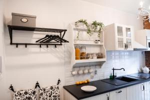 a kitchen with white cabinets and a black counter top at Apartamenty Pocztowa in Bydgoszcz