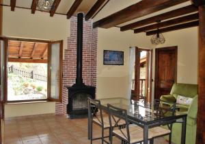 a living room with a glass table and a fireplace at Apart con piscina Lebanes Picos de Europa in Torices