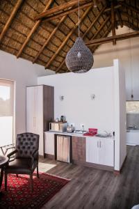 a kitchen with a table and a chair in a room at Kuwisa Lodge in Bela-Bela