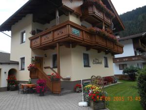 a building with a balcony and a table with flowers at Haus Elisabeth in Tux