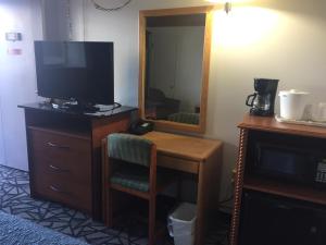 a room with a desk with a television and a mirror at Tomahawk Motor Lodge in Riverton