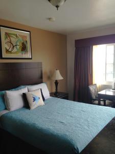 um quarto com uma cama grande e um cobertor azul em Morro Crest Inn em Morro Bay