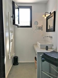 a bathroom with a sink and a window at Derrière la plage : suite, patio et pergola in Le Bois-Plage-en-Ré