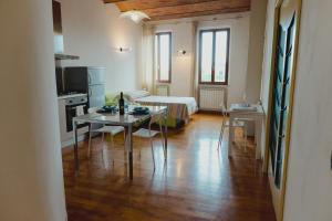 eine Küche und ein Wohnzimmer mit einem Tisch und einem Bett in der Unterkunft Monolocale panoramico San Martino 12 in Siena