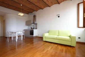 ein Wohnzimmer mit einem grünen Sofa und einem Tisch in der Unterkunft Monolocale panoramico San Martino 12 in Siena